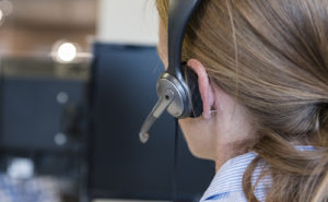 female customer support phone operator with headset  at workplace
